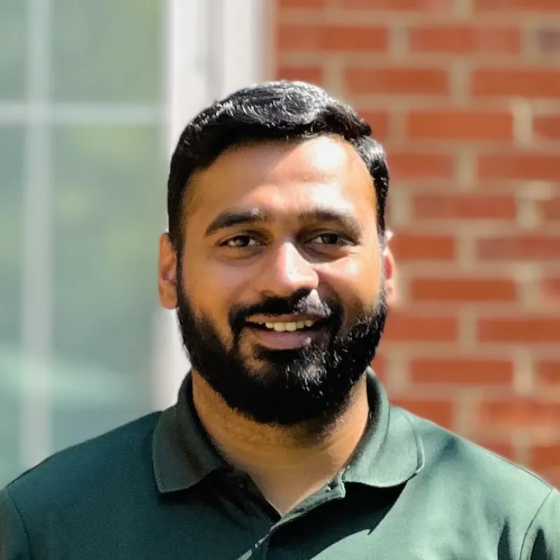 Man in green shirt looks at the camera and smiles